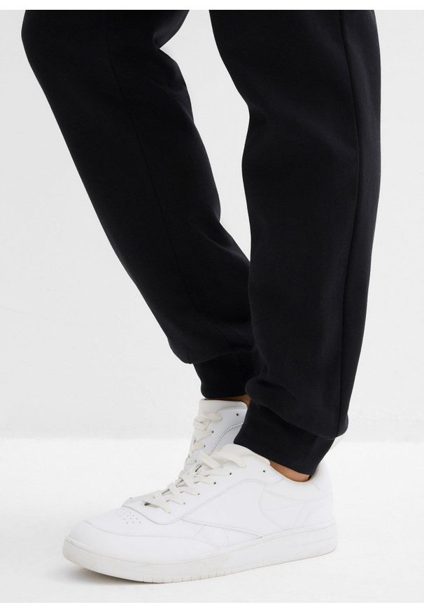 bonprix - Spodnie dresowe z prążkowanym ściągaczem w talii. Kolor: czarny. Materiał: prążkowany, dresówka. Styl: sportowy