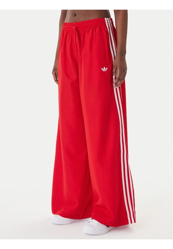 Adidas - adidas Spodnie dresowe Firebird Adilenium KD6299 Czerwony Regular Fit. Kolor: czerwony. Materiał: syntetyk