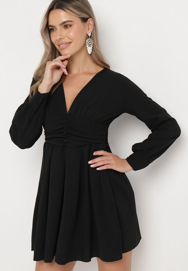Born2be - Czarna Rozkloszowana Sukienka Mini z Głębokim Dekoltem Ozdobiona Marszczeniem i Guzikami Jerikan. Kolor: czarny. Długość rękawa: długi rękaw. Wzór: aplikacja. Długość: mini