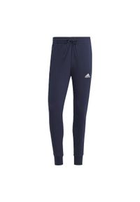Adidas - Spodnie dresowe męskie adidas Essentials French Terry Tapered Cuff 3-Stripes. Kolor: biały, wielokolorowy, czarny, niebieski. Materiał: dresówka