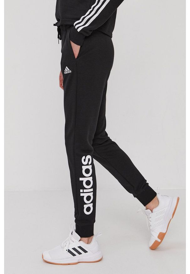 Adidas - adidas Spodnie damskie kolor czarny z nadrukiem. Kolor: czarny. Materiał: poliester. Wzór: nadruk