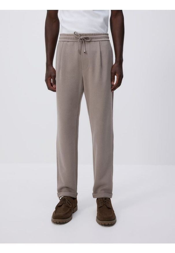 Reserved - Spodnie jogger z wiązaniem w pasie - beżowy. Kolor: beżowy. Materiał: bawełna, dzianina