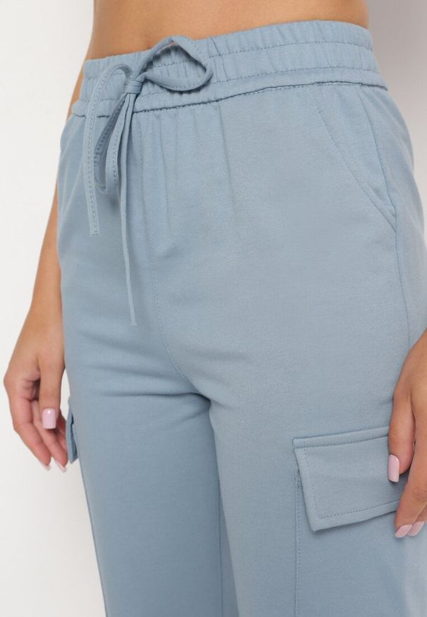 Born2be - Niebieskie Spodnie Dresowe z Bawełny z Szerokimi Kieszeniami Cargo Marnadala. Okazja: na co dzień. Kolor: niebieski. Materiał: bawełna, dresówka. Długość: długie. Sezon: wiosna, lato. Styl: casual