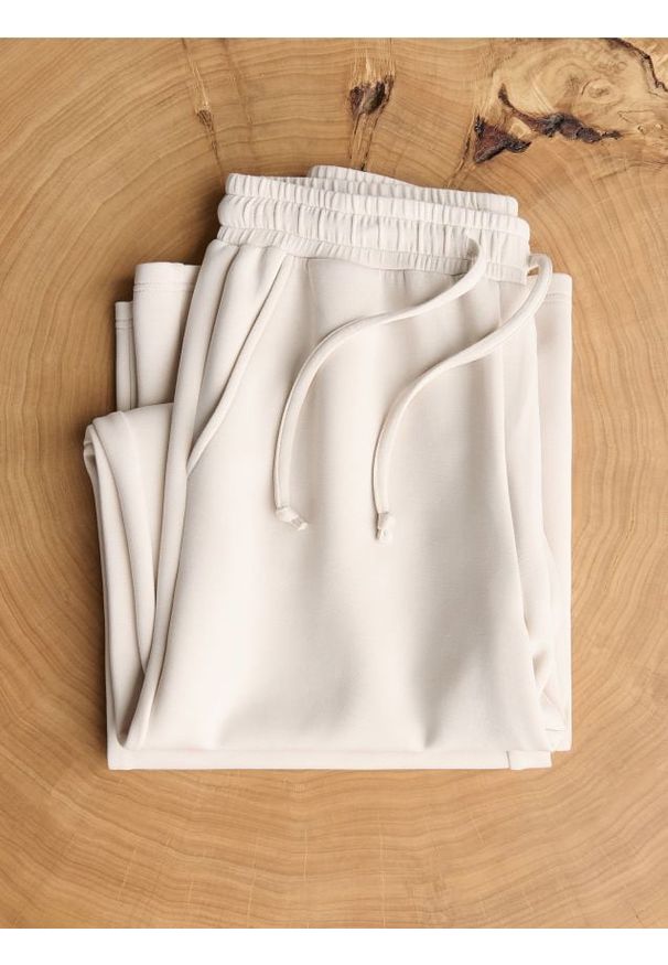 Reserved - Spodnie long leg - beżowy. Kolor: beżowy. Materiał: dzianina