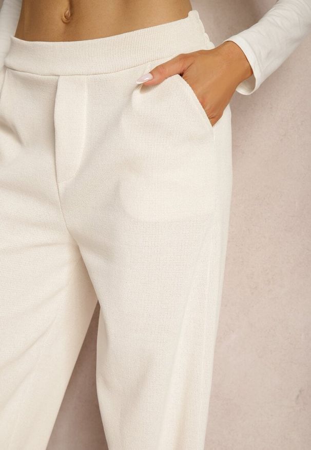 Renee - Jasnobeżowe Szerokie Spodnie Ozdobione Imitacją Kieszeni Tassae. Okazja: na co dzień. Stan: podwyższony. Kolor: beżowy. Materiał: bawełna. Wzór: aplikacja. Styl: casual, elegancki