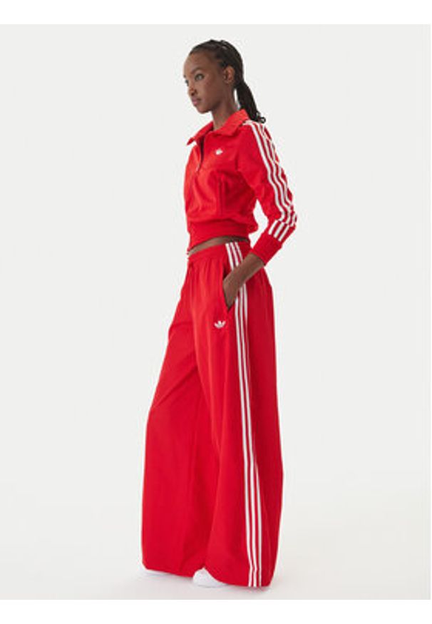 Adidas - adidas Spodnie dresowe Firebird Adilenium KD6299 Czerwony Regular Fit. Kolor: czerwony. Materiał: syntetyk