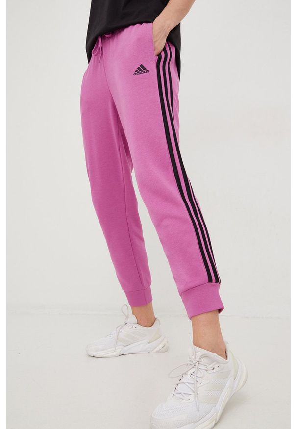 Adidas - adidas spodnie dresowe damskie kolor fioletowy z aplikacją. Kolor: fioletowy. Materiał: dresówka. Wzór: aplikacja