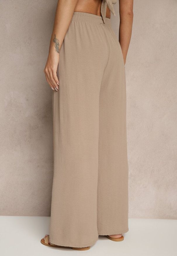 Renee - Ciemnobeżowe Spodnie z Bawełną o Szerokim Kroju Ozdobione Klamrą Reionis. Okazja: na co dzień. Stan: podwyższony. Kolor: beżowy. Materiał: bawełna. Wzór: aplikacja. Styl: casual, elegancki