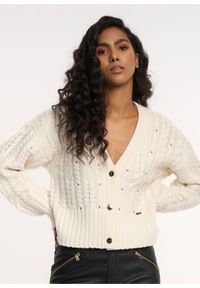 Ochnik - Kremowy sweter damski z nitami. Kolor: biały. Materiał: akryl. Długość: długie. Wzór: aplikacja