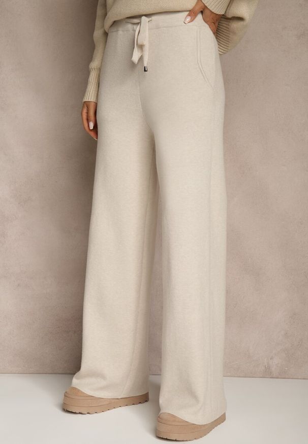 Renee - Jasnobeżowe Szerokie Spodnie Dzianinowe Ozdobione Sznurkami Meretusa. Okazja: na co dzień, do pracy, na spotkanie biznesowe. Stan: podwyższony. Kolor: beżowy. Materiał: dzianina. Wzór: aplikacja. Styl: biznesowy, klasyczny, casual