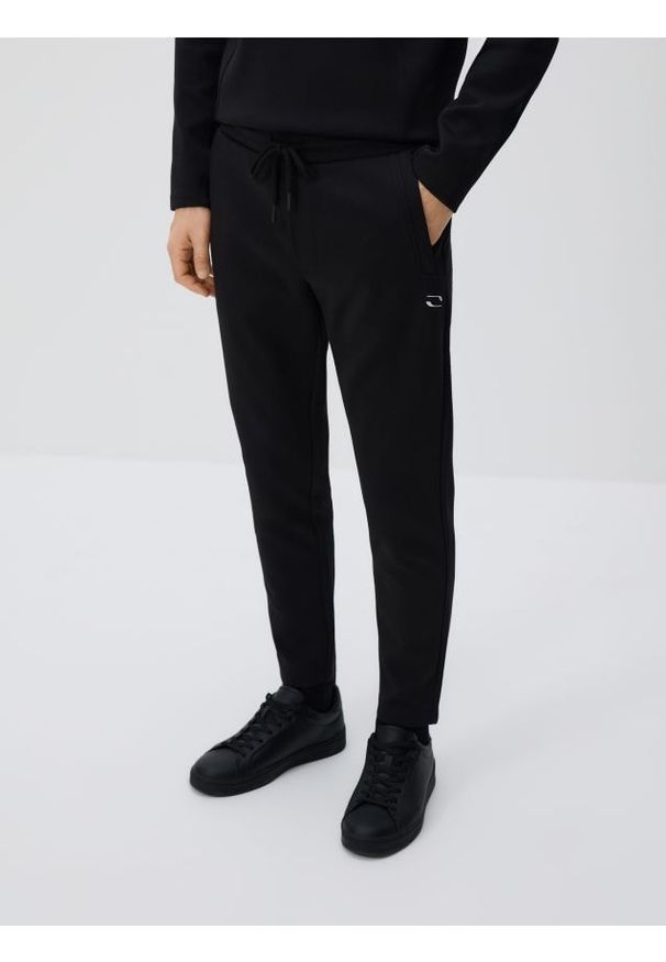 Reserved - Spodnie dresowe slim - czarny. Kolor: czarny. Materiał: dresówka