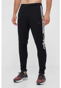 Adidas - adidas spodnie dresowe kolor czarny z nadrukiem. Kolor: czarny. Materiał: dresówka. Wzór: nadruk #1