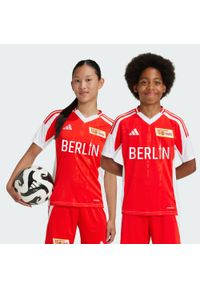 Adidas - Koszulka 1. FC Union Berlin 24/25 Home Kids. Kolor: czerwony, biały, wielokolorowy, różowy. Materiał: materiał
