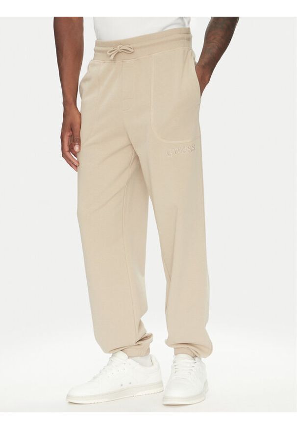 Guess Spodnie dresowe U5RB00 KCO31 Beżowy Regular Fit. Kolor: beżowy. Materiał: bawełna