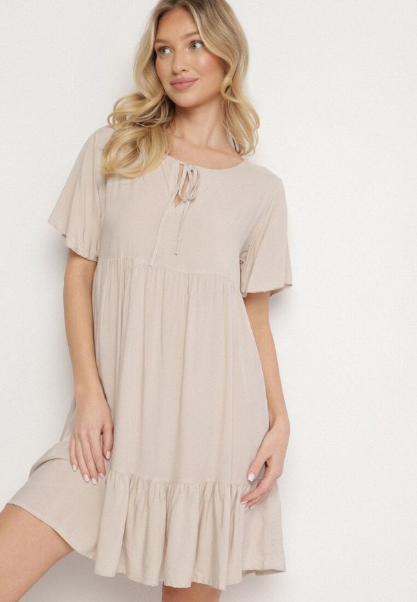 Born2be - Jasnobeżowa Sukienka z Bawełny o Rozkloszowanym Kroju z Wiązaniem przy Dekolcie Mepilea. Okazja: na co dzień. Kolor: beżowy. Materiał: bawełna. Długość rękawa: krótki rękaw. Sezon: wiosna, lato. Typ sukienki: rozkloszowane. Styl: klasyczny, casual, elegancki
