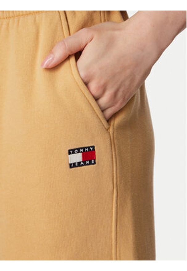 Tommy Jeans Spodnie dresowe Badge DW0DW23536 Beżowy Regular Fit. Kolor: beżowy. Materiał: bawełna