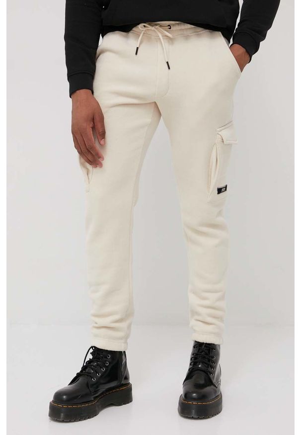 Jack & Jones spodnie męskie kolor beżowy gładkie. Kolor: beżowy. Materiał: dzianina. Wzór: gładki
