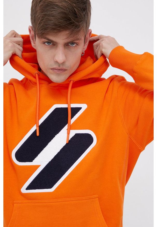 Superdry Bluza bawełniana męska kolor pomarańczowy z kapturem z aplikacją. Typ kołnierza: kaptur. Kolor: pomarańczowy. Materiał: bawełna. Wzór: aplikacja