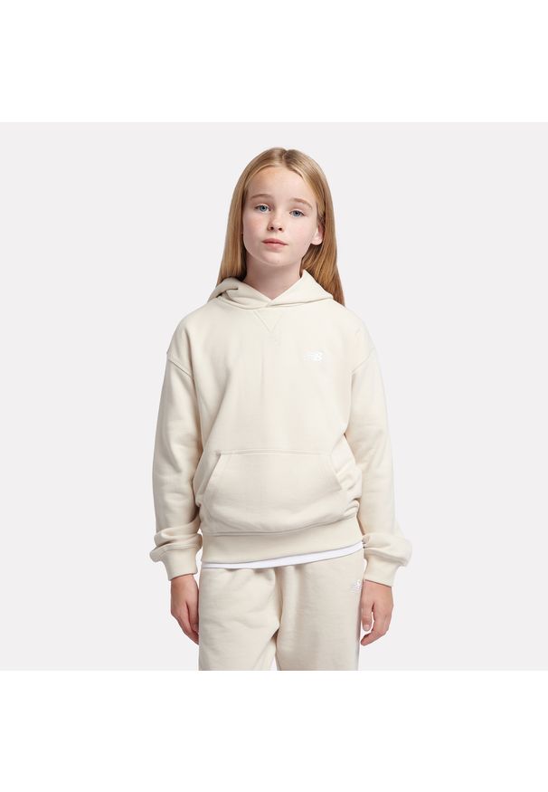 Bluza dziecięca New Balance LAKG0056LIN – beżowa. Typ kołnierza: kaptur. Kolor: beżowy. Materiał: bawełna, poliester. Wzór: aplikacja. Styl: sportowy
