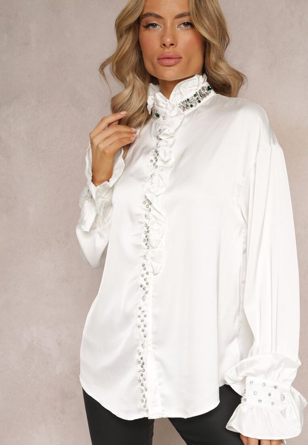 Renee - Biała Koszula z Lekko Bufiastymi Rękawami Ozdobiona Cyrkoniami i Falbankami oraz Stójką Shahirah. Typ kołnierza: kołnierzyk stójkowy, kołnierz z falbankami. Kolor: biały. Materiał: tkanina, satyna. Wzór: aplikacja