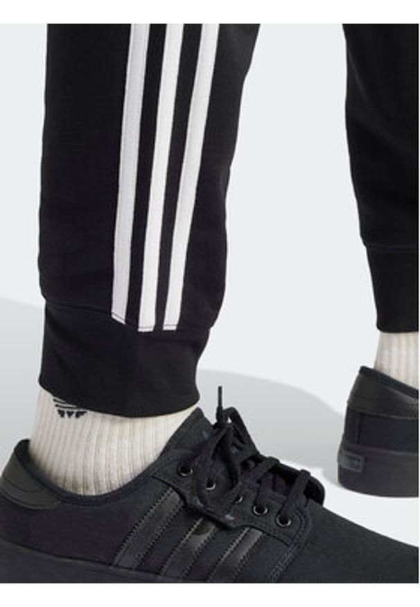 Adidas - adidas Spodnie dresowe adicolor 3-Stripes IU2353 Czarny Slim Fit. Kolor: czarny. Materiał: bawełna, syntetyk