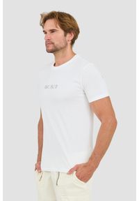 Guess - GUESS Biały t-shirt z haftowanym logo. Kolor: biały. Wzór: haft