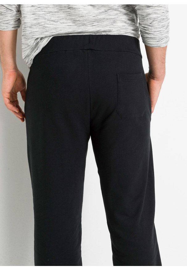 bonprix - Spodnie joggingowe z czystej bawełny organicznej. Kolor: czarny. Materiał: bawełna. Wzór: nadruk. Styl: sportowy