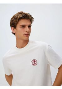 Reserved - T-shirt boxy z nadrukiem na plecach - złamana biel. Materiał: dzianina, bawełna. Wzór: nadruk #1