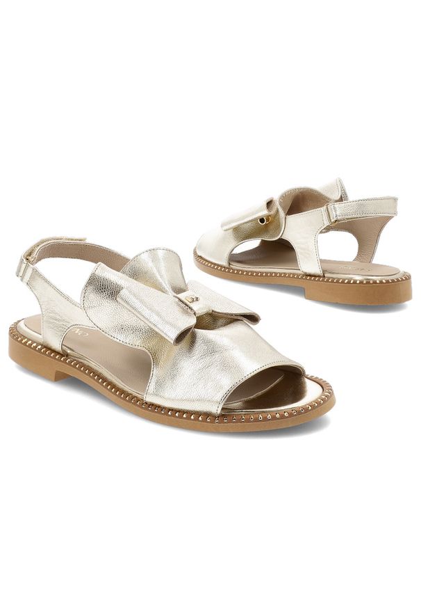 Złote Sandały Karino Stylowe Płaskie Obuwie Damskie. Okazja: na spacer, na imprezę. Zapięcie: pasek. Kolor: złoty. Materiał: skóra. Wzór: aplikacja. Sezon: lato. Obcas: na płaskiej podeszwie. Styl: elegancki