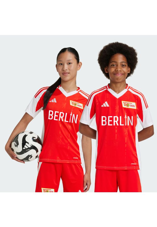 Adidas - Koszulka 1. FC Union Berlin 24/25 Home Kids. Kolor: czerwony, biały, wielokolorowy, różowy. Materiał: materiał