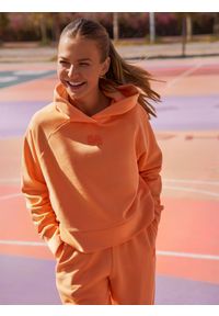 4f - Bluza dresowa z bawełną organiczną damska 4F x Anna Lewandowska. Okazja: na co dzień. Typ kołnierza: kaptur. Kolor: pomarańczowy. Materiał: bawełna, dresówka. Długość rękawa: raglanowy rękaw. Wzór: nadruk. Styl: sportowy, casual #1