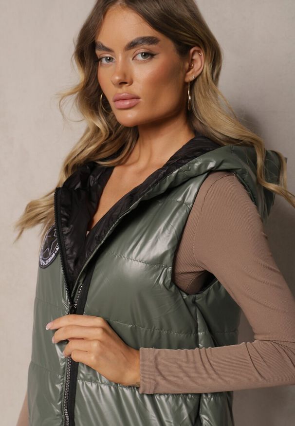 Renee - Zielona Długa Kamizelka Pikowana z Naszywką i Kapturem Mevianis. Okazja: na co dzień. Kolor: zielony. Materiał: bawełna, jeans. Długość: długie. Wzór: aplikacja. Styl: casual, sportowy