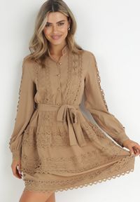 Born2be - Ciemnobeżowa Sukienka Koszulowa z Wiązanym Paskiem i Ażurowymi Taśmami Dimi. Typ kołnierza: kołnierzyk stójkowy. Kolor: beżowy. Materiał: materiał. Wzór: ażurowy. Typ sukienki: koszulowe. Długość: mini #3