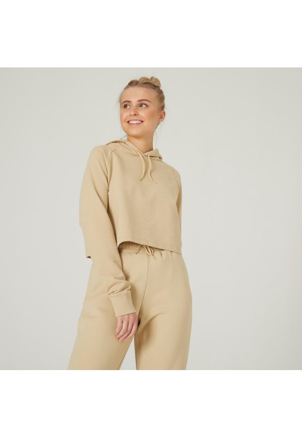 DOMYOS - Bluza z kapturem damska Nyamba Gym & Pilates 520 Crop. Typ kołnierza: kaptur. Kolor: beżowy. Materiał: dzianina, poliester, materiał, bawełna, włókno. Długość rękawa: długi rękaw. Długość: długie. Sport: joga i pilates