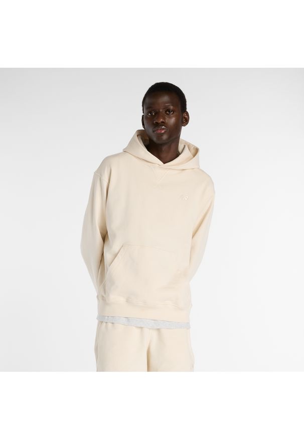 Bluza męska New Balance MT41534PEF – beżowa. Typ kołnierza: kaptur. Kolor: beżowy. Materiał: bawełna, prążkowany. Wzór: haft