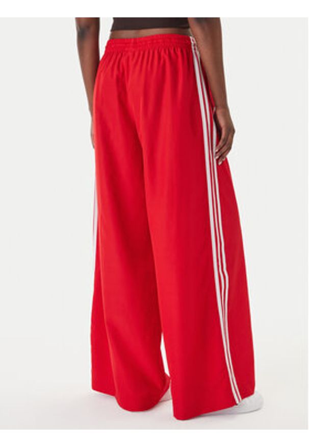 Adidas - adidas Spodnie dresowe Firebird Adilenium KD6299 Czerwony Regular Fit. Kolor: czerwony. Materiał: syntetyk