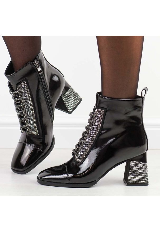 Czarne lakierowane botki damskie na słupku DiA 880-022. Okazja: na co dzień. Kolor: czarny. Materiał: skóra, lakier. Szerokość cholewki: normalna. Wzór: aplikacja. Sezon: zima, jesień. Obcas: na słupku. Styl: elegancki, casual, klasyczny