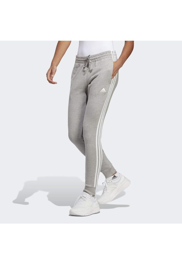 Adidas - Essentials 3-Stripes French Terry Cuffed Pants. Kolor: szary, biały, wielokolorowy. Materiał: materiał. Sport: fitness