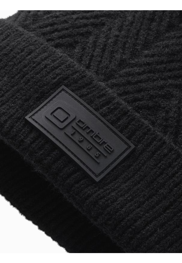 Ombre Clothing - Męska dzianinowa czapka o sweterkowym splocie z naszywką – czarna V1 OM-ACWH-0122 - uniwersalny. Kolor: czarny. Materiał: dzianina. Wzór: ze splotem, aplikacja. Styl: klasyczny, casual