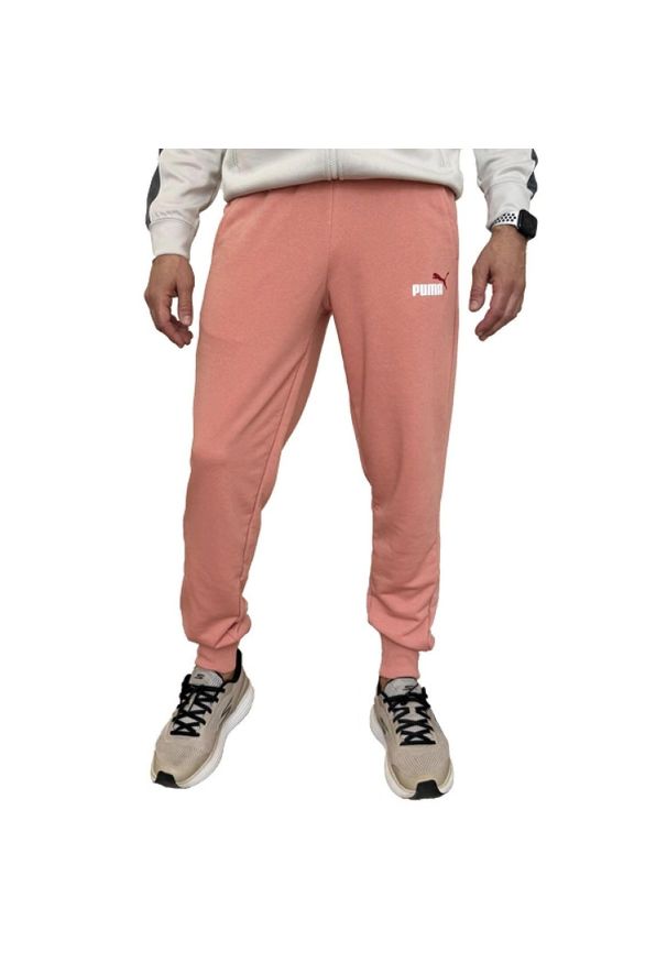 Puma - Spodnie Do Joggingu Męskie Logo ESS+. Kolor: pomarańczowy, wielokolorowy, żółty. Materiał: dresówka. Sport: bieganie