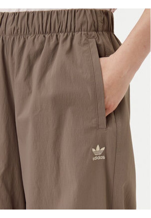 Adidas - adidas Spodnie dresowe Essentials Ripstop JD0783 Beżowy Loose Fit. Kolor: beżowy. Materiał: syntetyk