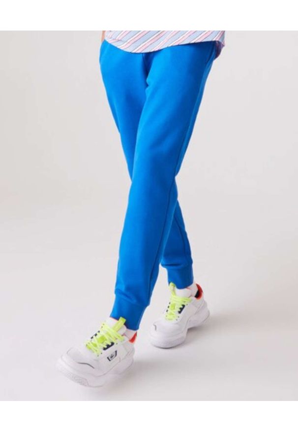 Lacoste - LACOSTE - Niebieskie spodnie dresowe Sport Tennis. Kolor: niebieski. Materiał: dresówka. Wzór: haft. Sport: kolarstwo, fitness