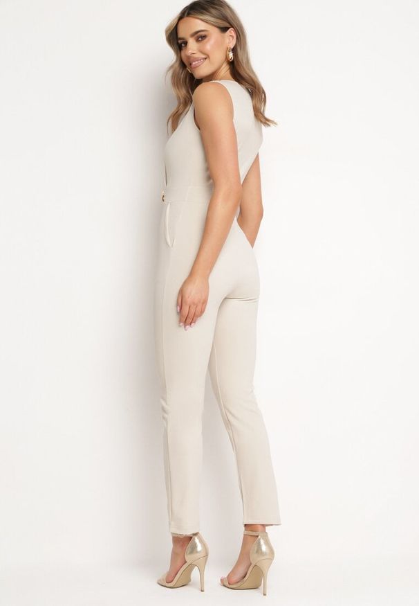 Born2be - Beżowy Kopertowy Kombinezon Bodycon bez Rękawów z Ozdobnym Łańcuchem Yaelia. Kolor: beżowy. Długość rękawa: bez rękawów. Długość: długie. Styl: elegancki