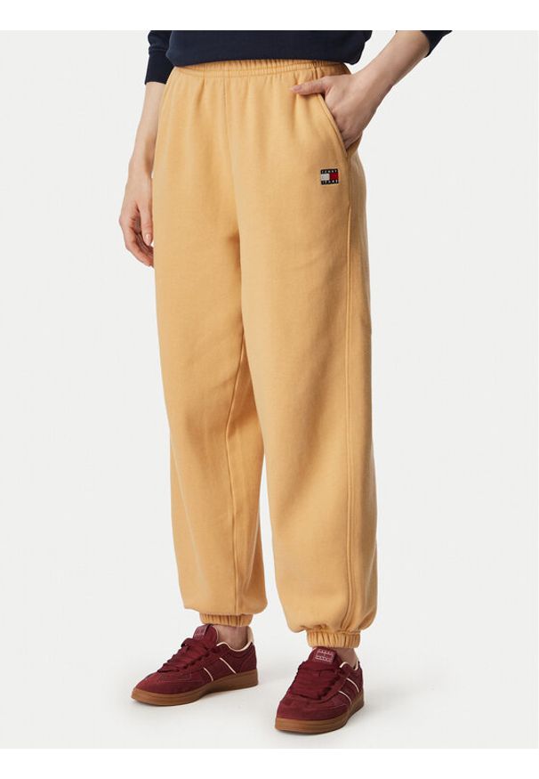 Tommy Jeans Spodnie dresowe Badge DW0DW23536 Beżowy Regular Fit. Kolor: beżowy. Materiał: bawełna