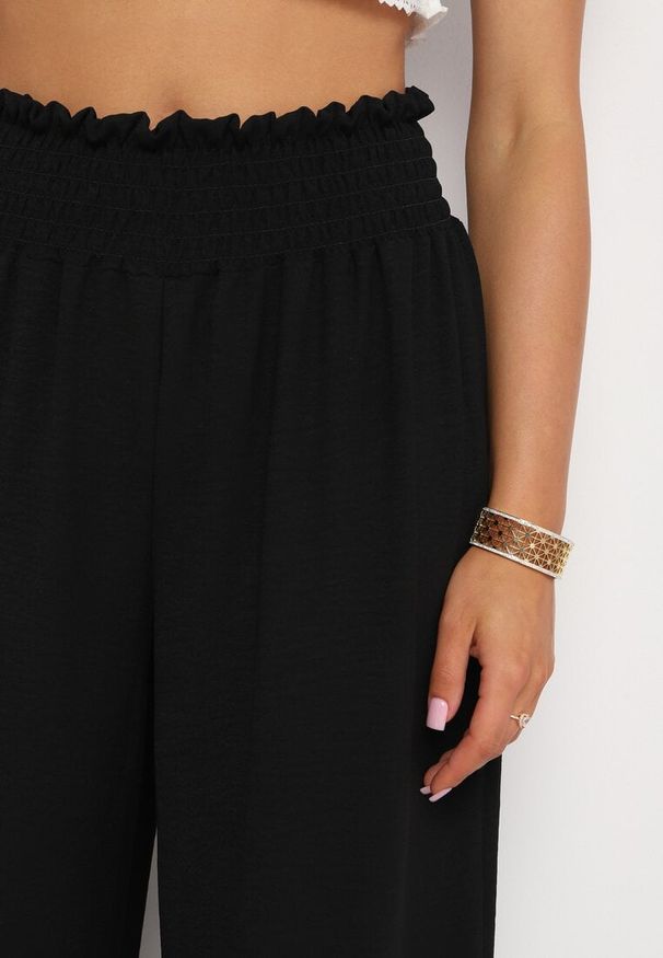 Born2be - Czarne Szerokie Spodnie z Wysokim Stanem Wykończone Gumką w Pasie Risinassa. Okazja: na spotkanie biznesowe. Stan: podwyższony. Kolor: czarny. Styl: biznesowy