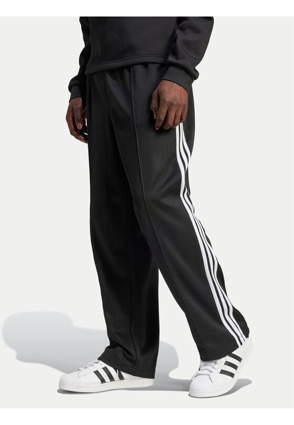 Adidas - adidas Spodnie dresowe adicolor Firebird IZ4801 Czarny Baggy Fit. Kolor: czarny. Materiał: bawełna