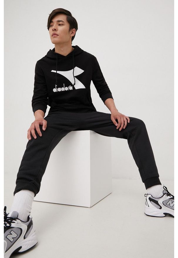 Diadora bluza męska kolor czarny z kapturem z nadrukiem. Typ kołnierza: kaptur. Kolor: czarny. Materiał: bawełna. Wzór: nadruk