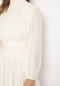 Born2be - Beżowa Sukienka Rozkloszowane ze Stójką Marszczeniami i Transparentnymi Ramionami Belabria. Okazja: na co dzień. Typ kołnierza: kołnierzyk stójkowy. Kolor: beżowy. Typ sukienki: rozkloszowane. Styl: casual, klasyczny #6