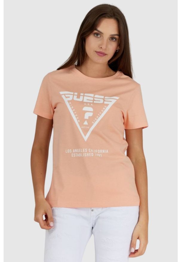 Guess - GUESS Brzoskwiniowy t-shirt damski z białym logo. Kolor: pomarańczowy. Materiał: bawełna. Wzór: nadruk