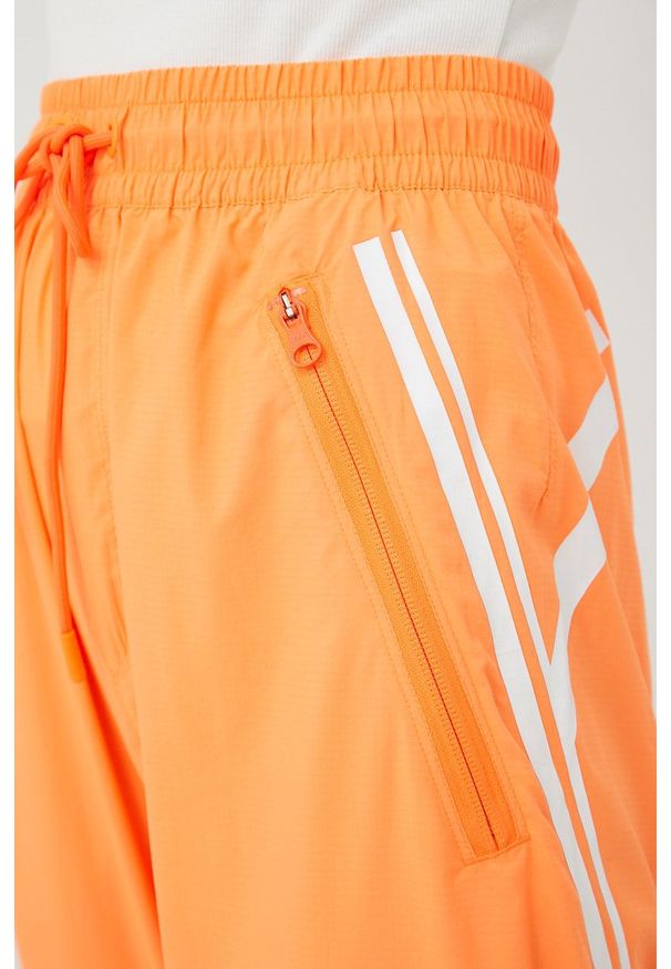 Adidas by Stella McCartney - adidas by Stella McCartney spodnie treningowe Truepace damskie kolor pomarańczowy z nadrukiem. Kolor: pomarańczowy. Materiał: materiał. Wzór: nadruk